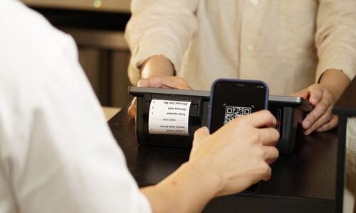 福岡の飲食店が公式LINEの友だち登録を増やすため、来店客にQRコードを案内しているカウンター越しのシーン